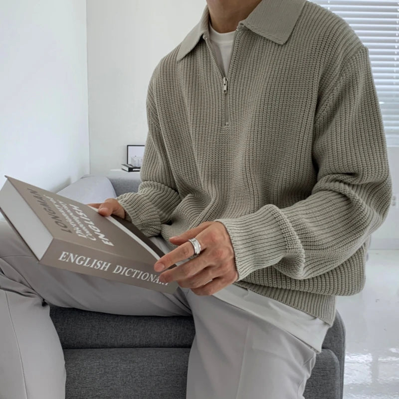 pull de couleur gris portée par un homme de profil assit